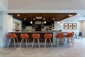 a kitchen with a bar with orange stools at Holiday Inn - Tampa North by IHG in Tampa
