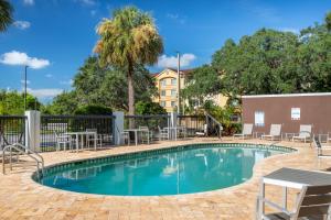 a swimming pool with tables and chairs next to a building at Holiday Inn - Tampa North by IHG in Tampa