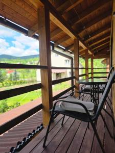 a porch with two chairs and a table on it at HIT- house in Slavske