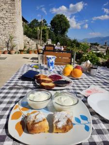 a table with plates of food on a checkered table cloth at Guri Guesthouse in Gjirokastër