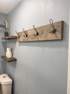 a bathroom with a toilet and three hooks on the wall at The Mark at Surfside #8 in Surfside Beach +17 photos
