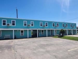 a blue building with a parking lot in front of it at The Mark at Surfside #8 in Surfside Beach
