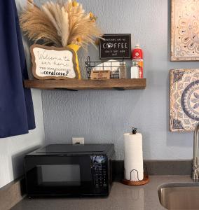a kitchen counter with a microwave and a sink at The Mark at Surfside #8 in Surfside Beach