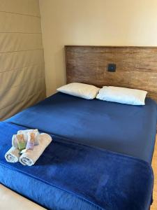 a bed with blue sheets and towels on it at Refúgio Morumbi: Piscina aquecida e espaço gourmet in São Paulo +39 photos