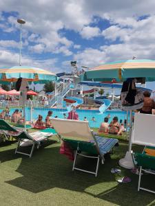 a water park with a pool and chairs and people at Hotel Astoria in Riccione