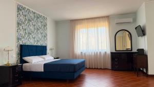 a bedroom with a blue bed and a mirror at Villa O'Serbante in Sant'Agnello