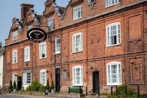 a large brick building with a clock on it at The Scole Hotel in Scole +31 photos