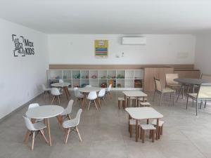 a classroom with tables and chairs in a room at Flat na Praia dos Carneiros - Resort Max Carneiros Suítes in Tamandaré