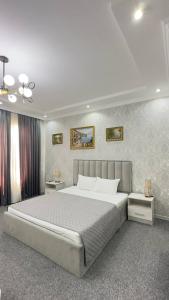 a bedroom with a large bed and two night stands at Hotel Imam Azam in Samarkand