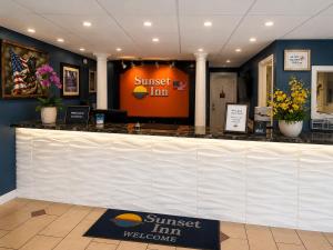 a sunburst inn lobby with a white counter top at Sunset Inn in Jacksonville