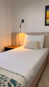a bedroom with a white bed and a lamp at White house 2 Ksamil in Sarandë +24 photos