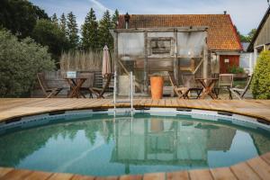 a swimming pool with a deck and a house at Lakamajutus, telkimisala ja saunakompleks Pihtla Õlleköögis in Pihtla +23 photos