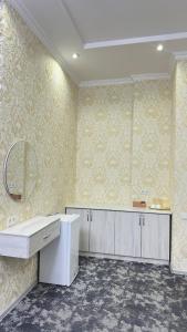 a bathroom with a white counter and yellow wallpaper at Hotel Imam Azam in Samarkand +26 photos