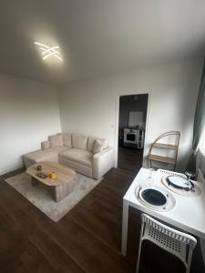 a living room with a couch and a table at Charmant T2 cosy au cœur de Caen Parking gratuit et arrivée autonome in Caen
