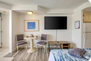 a hotel room with a bed and a table and a tv at Oceanfront Condo at Daytona Beach Resort in Daytona Beach