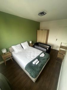a bedroom with a bed with a green wall at Charmant T2 cosy au cœur de Caen Parking gratuit et arrivée autonome in Caen