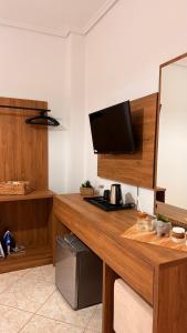 a room with a wooden desk with a television on it at White house 2 Ksamil in Sarandë