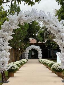 an arch covered in white flowers and plants at Bom sossego in Foz do Iguaçu