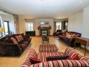 a large living room with couches and a piano at Bib Knowl Farm in Littleborough