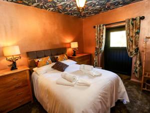 a bedroom with a large bed with towels on it at Bib Knowl Farm in Littleborough +82 photos