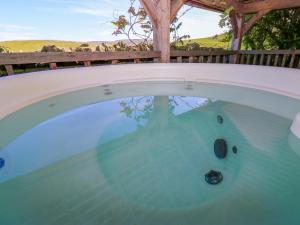 a swimming pool with a table and a wooden fence at Bib Knowl Farm in Littleborough