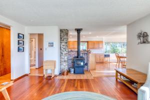 a living room with a fireplace and a stove at Bamboo House - Meredith Lodging in Nehalem