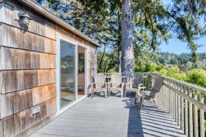 a wooden deck with chairs and a table on it at Bamboo House - Meredith Lodging in Nehalem