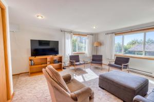 a living room with a tv and a couch and chairs at Bamboo House - Meredith Lodging in Nehalem