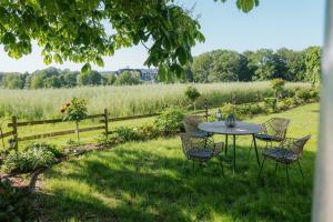 a table and chairs in a yard with a field at Ferienhaus am Dillbach in Hagen +8 photos