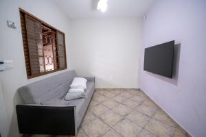 a living room with a couch and a flat screen tv at Casa com Piscina Aquecida e Churras em Uberlândia in Uberlândia