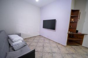 a living room with a couch and a flat screen tv at Casa com Piscina Aquecida e Churras em Uberlândia in Uberlândia