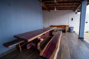a large wooden table in a room with benches at Casa com Piscina Aquecida e Churras em Uberlândia in Uberlândia