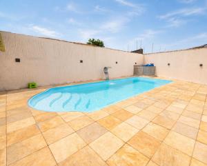 a swimming pool in the middle of a tiled patio at Casa com Piscina Aquecida e Churras em Uberlândia in Uberlândia