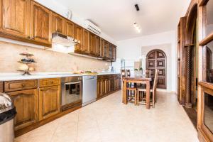 a large kitchen with wooden cabinets and a table at Guesthouse Tuta in Pakoštane