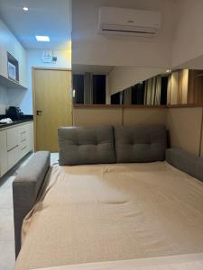 a large bed in a room with a couch at Flat has rooftop with barbecue and sea view in Tamandaré +16 photos