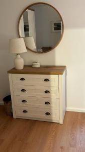 a dresser with a mirror and a lamp on it at Heefkant Haus Heefkant, HK 03 in Rantum
