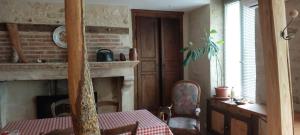 a dining room with a table and a fireplace at Gîte des petits givrés in Entrains-sur-Nohain