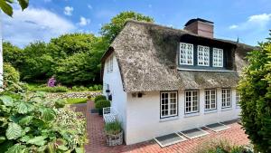 an old cottage with a thatched roof at Friesenhaus Hideaway Hüs in Morsum