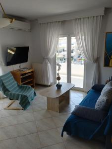 a living room with a couch and a tv at Peramos Luxury 2 in Nea Peramos