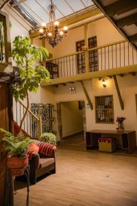 a large room with a couch and a staircase at Hostal Mallqui in Cusco