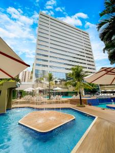 a pool with a fountain in front of a building at Mar Hotel Conventions in Recife