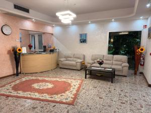 a lobby with a waiting room with couches and a table at Hotel Anny in Cervia