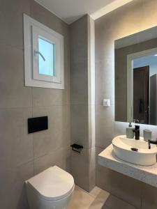 a bathroom with a white toilet and a sink at Sofia Studios in Benitses