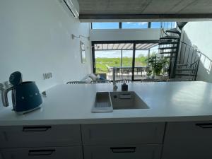 a kitchen counter with a sink and a window at Hampton Zalew Zegrzyński in Cupel