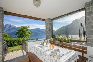 a dining room with a view of a lake and mountains at Casa dei Galli in Gravedona