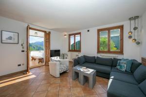 a living room with a blue couch and a table at Casa dei Galli in Gravedona