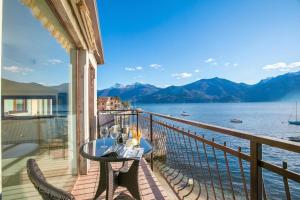 a balcony with a table and chairs and a view of the water at Menaggio Tosca Apartments in Menaggio