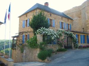 a stone house with flowers on the side of it at Chateau Cottage in Carlux