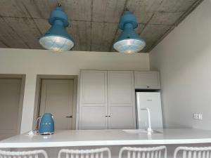 a kitchen with blue lights hanging from the ceiling at Hampton Zalew Zegrzyński in Cupel
