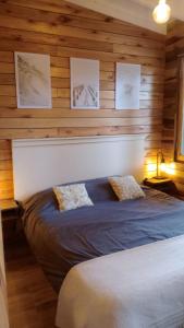 a bedroom with a large bed in a wooden wall at Alma in Pinamar